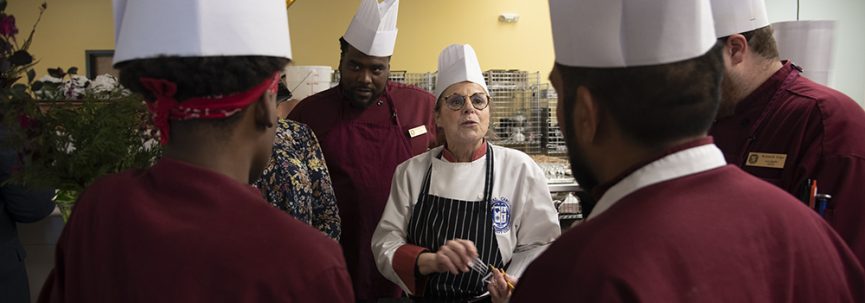 Coastal culinary students listening to an instructor
