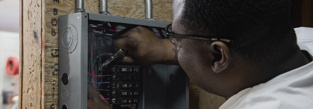 Coastal college student working on electrical fusebox