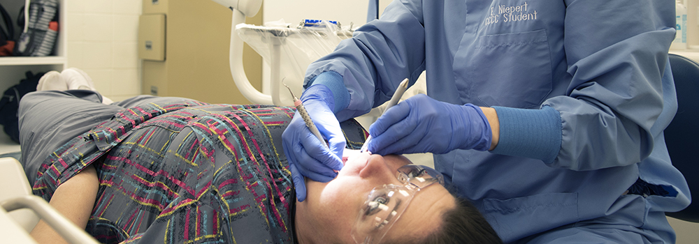 a Photo of a student performing a dental hygiene exam