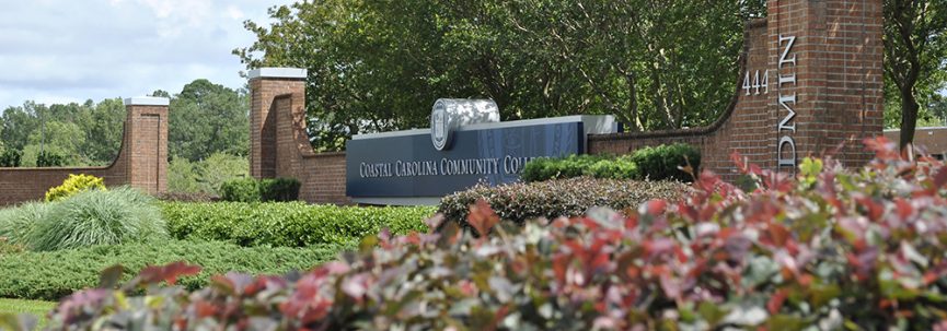 A photo of the entrance sign to campus in front of the admin building