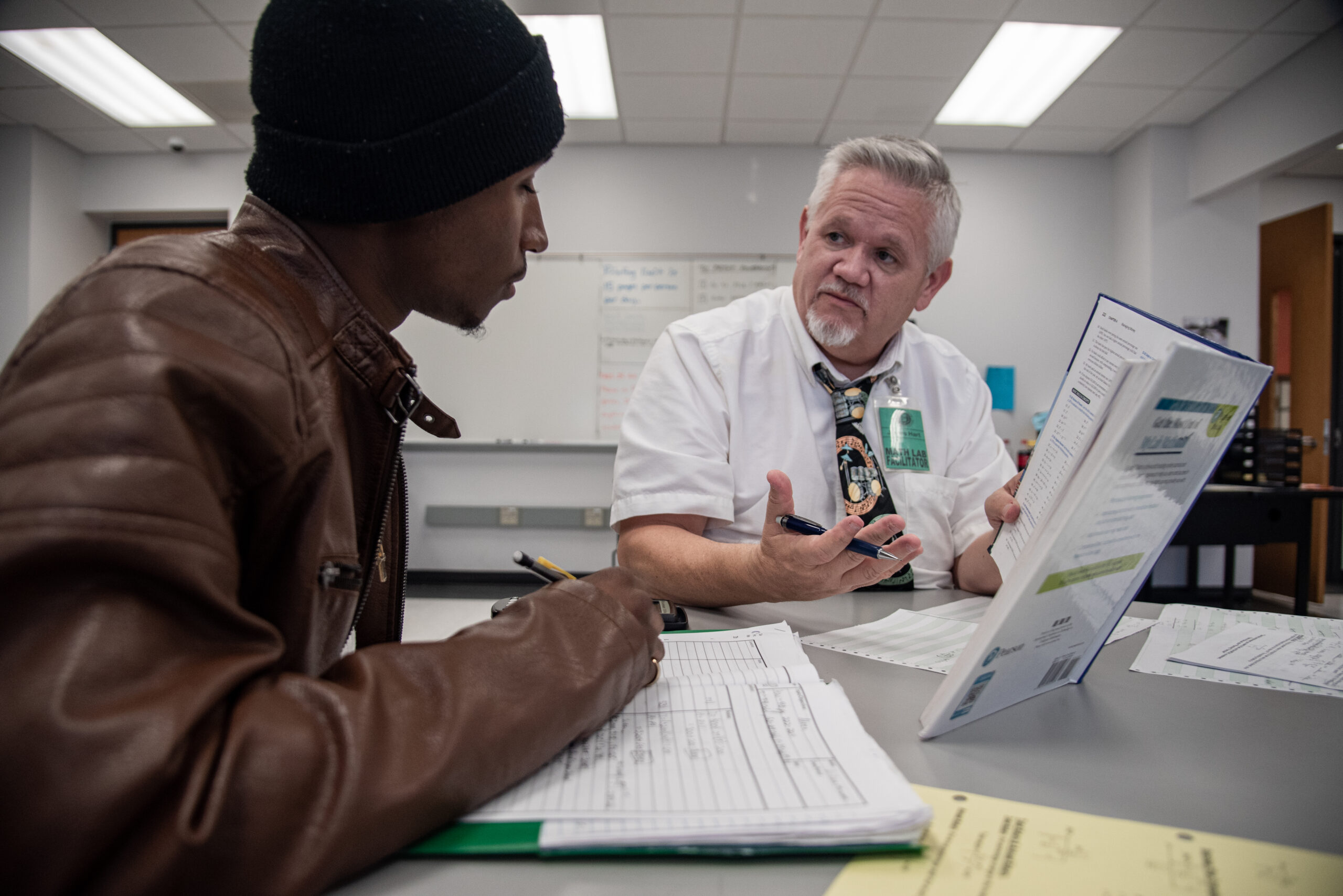 Teacher talking to and helping a student.